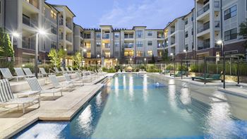 an apartment building with a swimming pool and lounge chairs at The Hendrix, Atlanta, GA, 30329